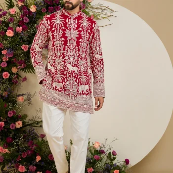 Red short kurta with tropical flora and fauna embroidery, ivory threadwork, and delicate sequin detailing for refined occasion wear